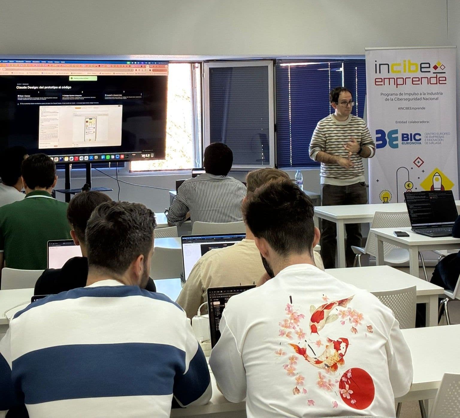 Sesión práctica con una terminal de Claude Code proyectada en el aula